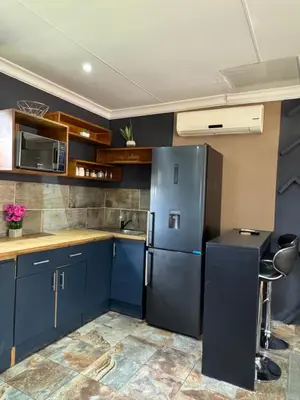 a kitchen with blue cabinets and a refrigerator at Spacious stay-in 1bedroom apartment in Kempton Park
