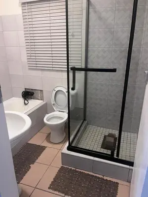 a bathroom with a shower with a toilet and a sink at Cosy duplex in the heart of Midrand in Midrand