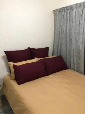 a bedroom with a large bed with red pillows at Cosy duplex in the heart of Midrand in Midrand