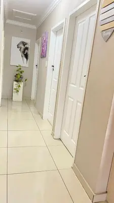 a hallway with a white door and a tile floor at SummerPlace Guest Rooms in Modimolle