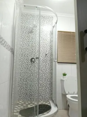 a bathroom with a shower with a glass door at SummerPlace Guest Rooms in Modimolle