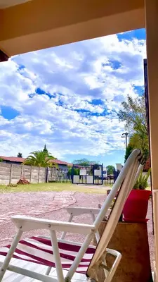 a white rocking chair sitting on a porch at SummerPlace Guest Rooms in Modimolle