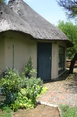 a small house with a thatched roof and a brick walkway at Grootgeluk in Naboomspruit