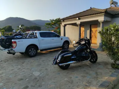 a motorcycle and a truck parked next to a house at Kanganyisa guest house in Tzaneen