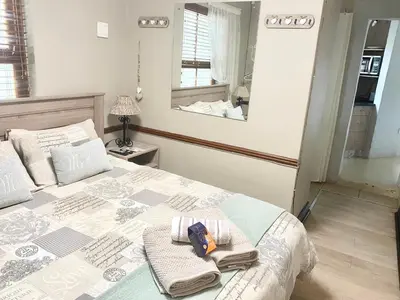 a bedroom with a bed with towels and a mirror at VILLA GUEST Suite in Pretoria