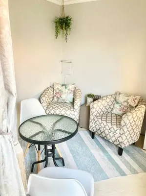 a living room with a table and a chair and a couch at VILLA GUEST Suite in Pretoria
