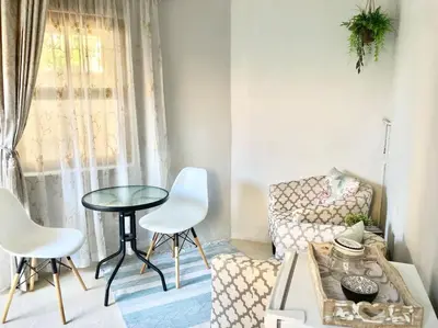 a living room with a couch and a table and chairs at VILLA GUEST Suite in Pretoria