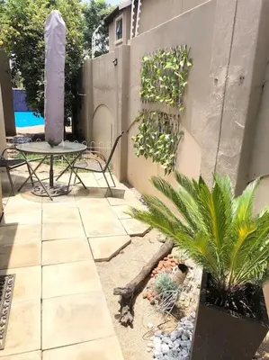 a patio with a table and some plants on it at VILLA GUEST Suite in Pretoria