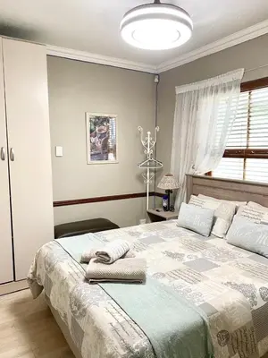 a bedroom with a large bed with towels on it at VILLA GUEST Suite in Pretoria