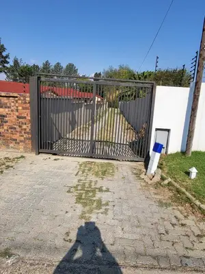 a shadow of a person standing in front of a gate at Limewood Pool view in Sandton