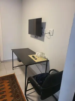 a table with a chair and a television on a wall at Limewood Pool view in Sandton