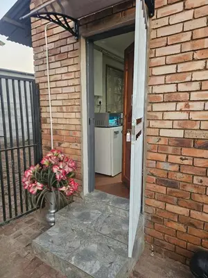 a brick building with a door leading to a kitchen at American horses in Pretoria