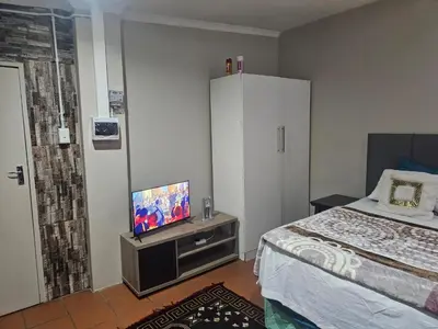a bedroom with a bed and a flat screen tv at American horses in Pretoria