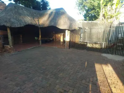 a fence with an umbrella and a brick patio at American horses in Pretoria