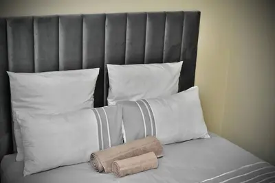 a bed with white pillows and a headboard at SEEYAs Nest in Mataffin