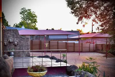 a building with a fence in front of a yard at SEEYAs Nest in Mataffin