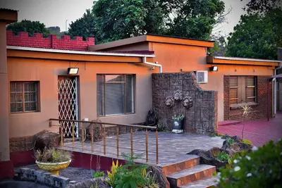 an orange house with a staircase in front of it at SEEYAs Nest in Mataffin