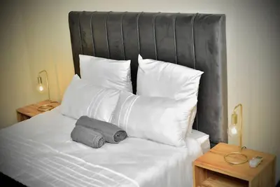 a bed with white pillows and a gray object on it at SEEYAs Nest in Mataffin