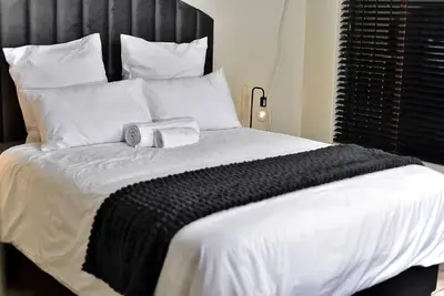 a bed with a black and white blanket on it at SEEYAs Nest in Mataffin