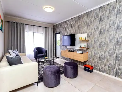 a living room with a couch and a tv at Urban Retreat in Midrand