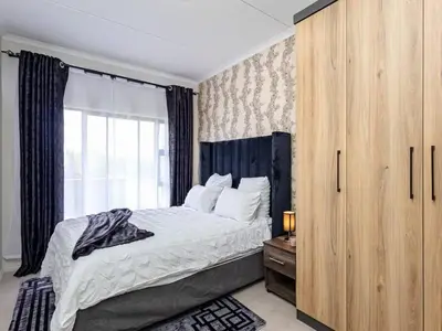 a bedroom with a large bed and a window at Urban Retreat in Midrand