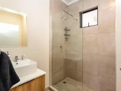 a bathroom with a shower and a sink at Urban Retreat in Midrand