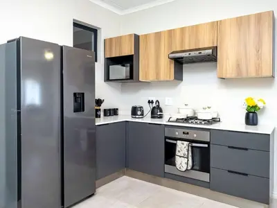 a kitchen with a stainless steel refrigerator and cabinets at Urban Retreat in Midrand