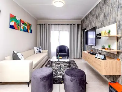 a living room with a couch and two purple stools at Urban Retreat in Midrand