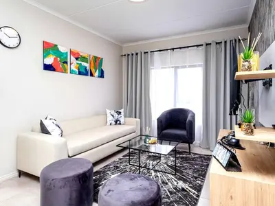 a living room with a couch and a table at Urban Retreat in Midrand