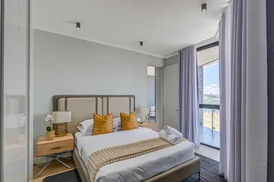 a bedroom with a bed and a large window at Waterfall Luxury Suites in Midrand