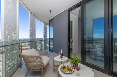 a room with a balcony with a bowl of fruit on a table at Waterfall Luxury Suites in Midrand
