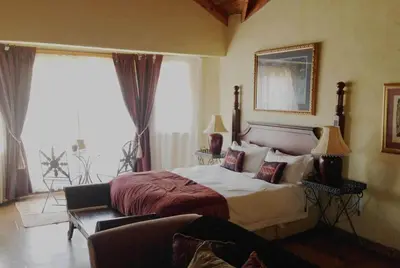 a bedroom with a bed and a couch at Fox & Squirrel in Dullstroom