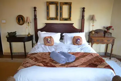 a bedroom with a bed with two pillows on it at Fox & Squirrel in Dullstroom