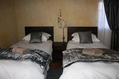 two beds sitting next to each other in a room at Fox & Squirrel in Dullstroom
