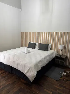 a bedroom with a large bed with white sheets and pillows at Kioma Guest House in Mokopane
