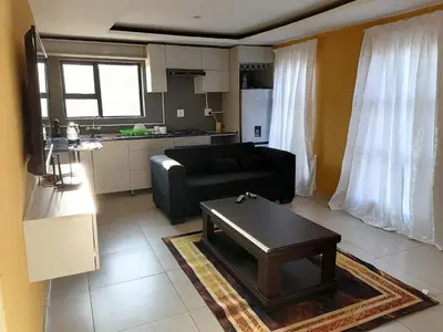 a living room with a black couch and a table at Sibusisiwe in Acornhoek