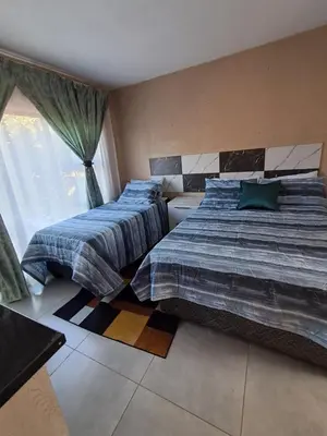 a bedroom with two beds and a window at Sibusisiwe in Acornhoek