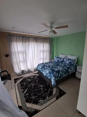 a bedroom with a bed and a ceiling fan at Sibusisiwe in Acornhoek