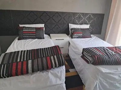 a room with two twin beds with white sheets at Sibusisiwe in Acornhoek