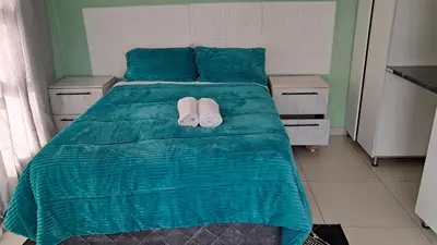 a bed with two white slippers on top of it at Sibusisiwe in Acornhoek