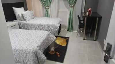 a room with two beds and a table with an umbrella at Sibusisiwe in Acornhoek