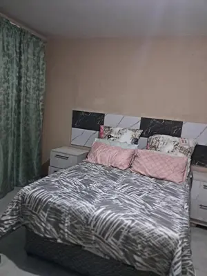 a bedroom with a large bed with a black and white comforter at Sibusisiwe in Acornhoek