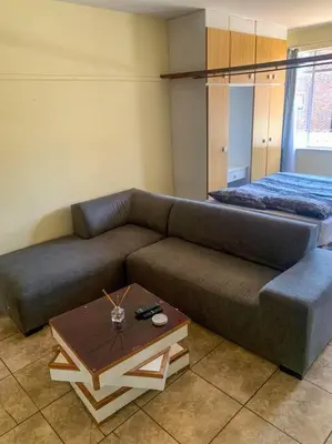 a living room with a couch and a bed at Spacious, Budget-Friendly Stay in Pretoria