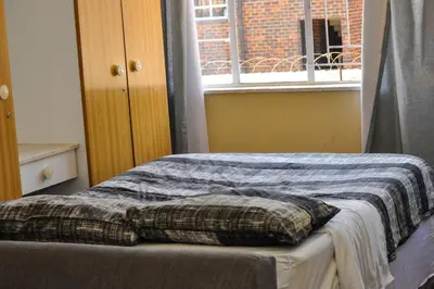a bedroom with a bed with a blanket and a window at Spacious, Budget-Friendly Stay in Pretoria
