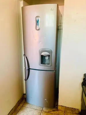 a stainless steel refrigerator in a corner of a room at Spacious, Budget-Friendly Stay in Pretoria