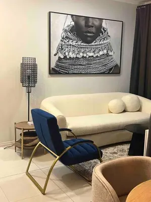 a living room with a couch and a blue chair at The Henlee Apartment on New - Power Backup, Gym ,Pool in Midrand