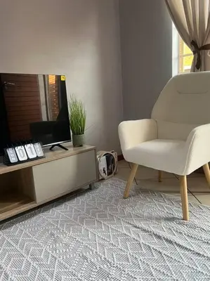 a living room with a chair and a television at Homie my home in Centurion