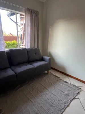 a living room with a couch and a window at Homie my home in Centurion