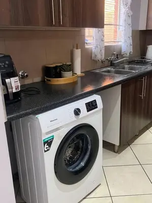 a kitchen with a washing machine under a counter at Homie my home in Centurion
