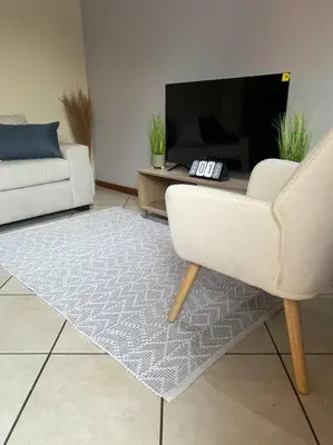 a living room with a couch and a tv at Homie my home in Centurion